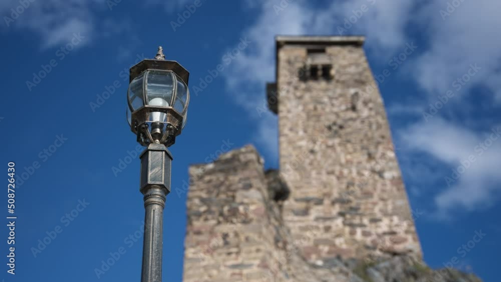 Close up of street lantern light with ancient Svan Tower of Georgia in the blurred background. Slow motion. Close up of street lantern light with ancient Svan Tower of Georgia in the blurred background. Slow motion.