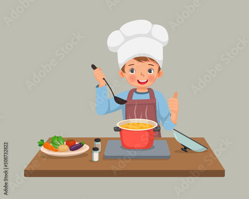cute little boy chef cooking delicious vegetable soup showing thumb up