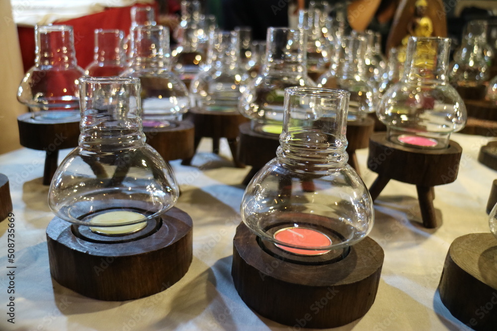 There are many candlesticks made of clear glass on the table There are many candlesticks made of clear glass on the table