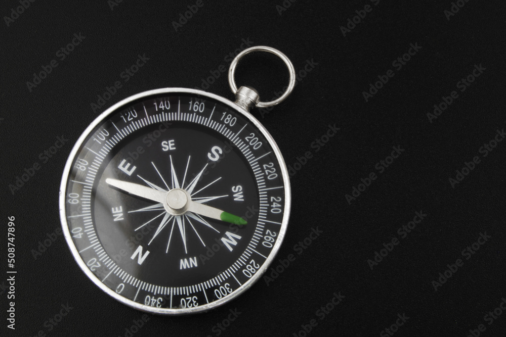 Black round compass on black background close-up. Black round compass on black background close-up.