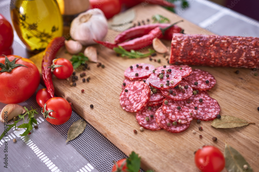 Sliced salami sausage on wooden cutting board at domestic kitchen Sliced salami sausage on wooden cutting board at domestic kitchen