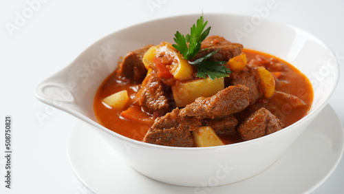 Beef goulash, soup and a stew, made of beef chuck steak, potatoes and plenty of paprika. Hungarian  traditional meal.