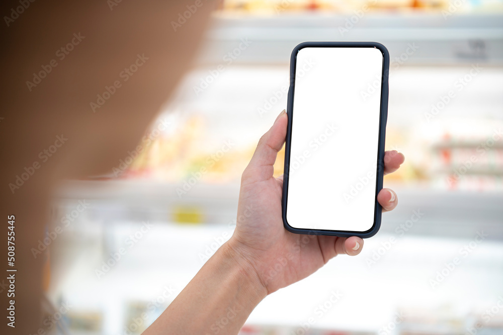 woman hand holding and using at touch screen smart phone (mobile) over blurred people background in supermarket;shopping