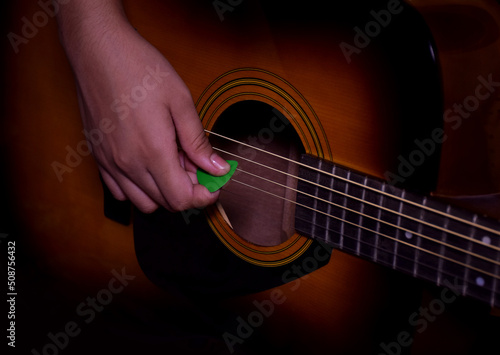 Close up of a hand strumming or playing a guitar