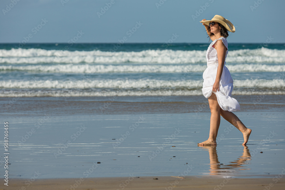 Naklejka premium Woman walking near sea and admiring beach