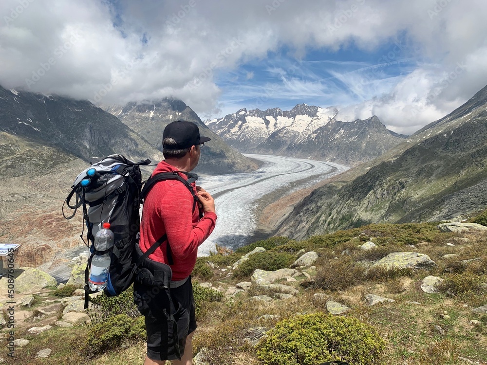 Wanderer, Bergführer schaut auf Aletschgletscher und die Walliser Berge Aletschhorn, Jungfrau Joch, Bettmerhorn  auf der Riederalp im Wallis. - grösste und längste  Gletscher  der Alpen / Schweiz