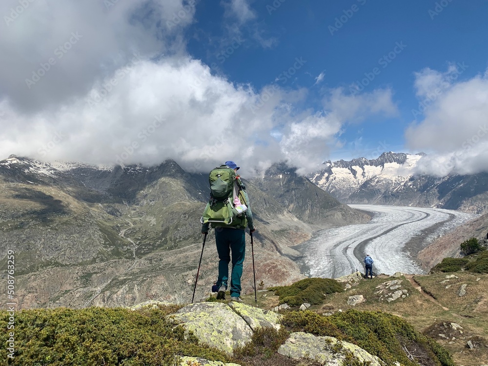 Wanderer - am Aletschgletscher auf der Riederalp im Wallis, - Frau mit Baby im Tragerucksack. Im Hintergrund Panorama Schneeberge