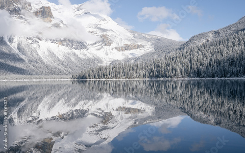 Still alpine lake reflecting its winter surroundings like a mirror, Yoho N. Park, Canada