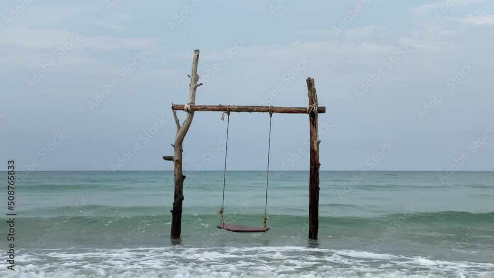 Beach swing and watching ocean waves. Carefree summer moment at ocean beach. Beach swing and watching ocean waves. Carefree summer moment at ocean beach.