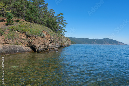 Lake Baikal coast, hill with forest, water bay. Summer travel, discovery of beauty of Earth. Siberia, Russia. © Иван Грабилин