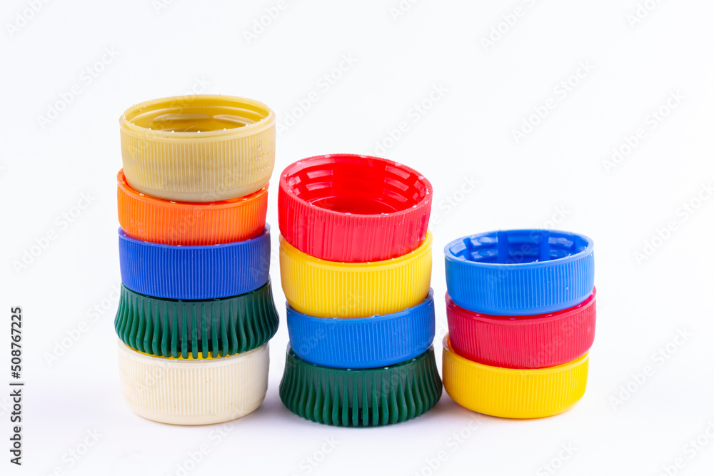 Pile of colored plastic caps on white background. Recycling concept. Pile of colored plastic caps on white background. Recycling concept.