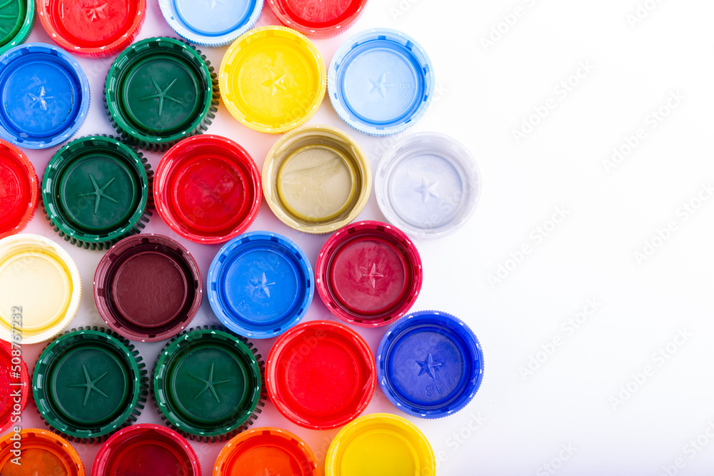 Plastic bottle caps on white background. Cap material is recyclable. Recycling collection and processing plastic bottle caps. Plastic bottle caps on white background. Cap material is recyclable. Recycling collection and processing plastic bottle caps.