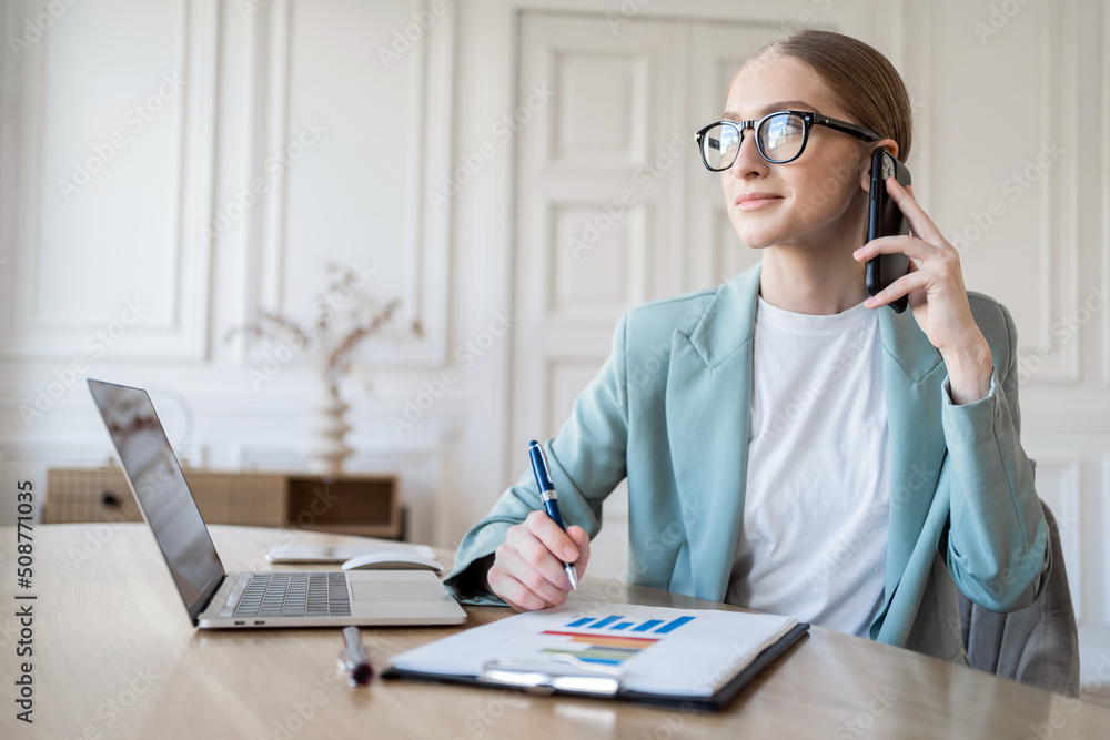 Female manager with glasses workplace in office, uses laptop computer Female manager with glasses workplace in office, uses laptop computer