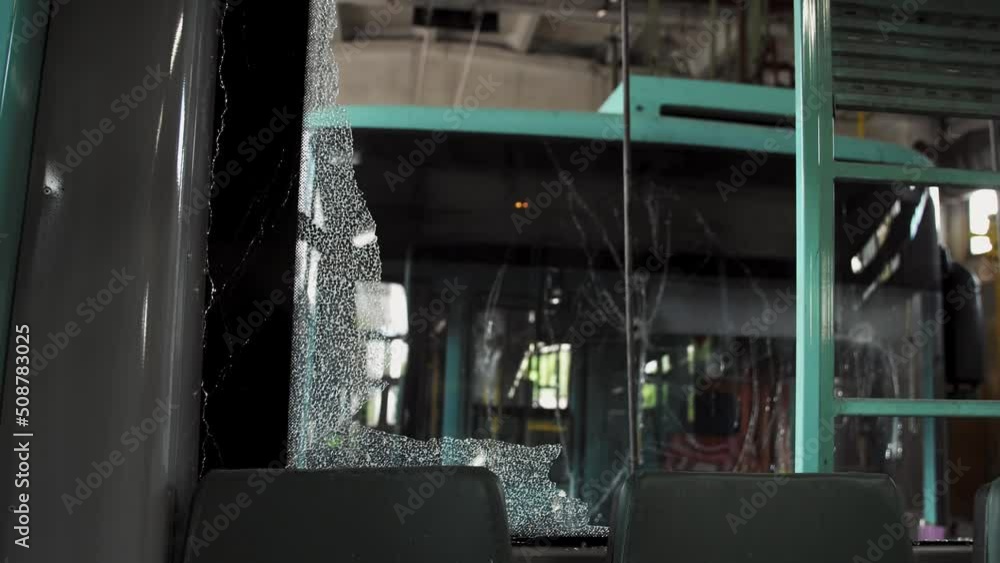 Broken window glass of a trolleybus or bus after an accident. View from the interior of a broken public transport. The result of a collision between two large vehicles. Broken window glass of a trolleybus or bus after an accident. View from the interior of a broken public transport. The result of a collision between two large vehicles.
