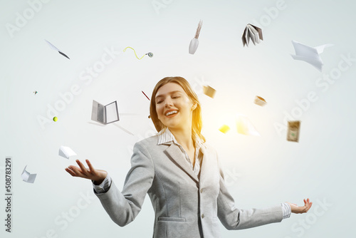 Tablou pe pânză Young pretty businesswoman juggling with business items