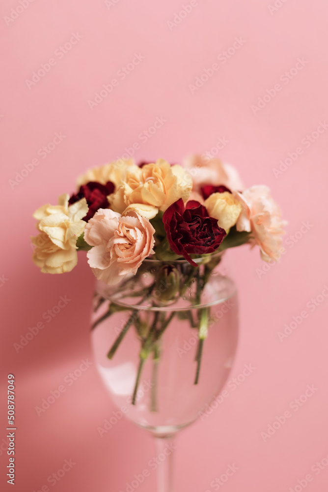adorable little bunch of pinks carnations in a glass pink background