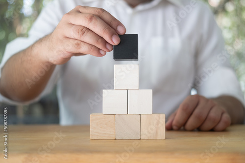 Man arranging blank wooden cubes