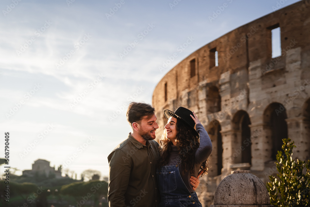 Young romantic couple having tender moment in front of Rome Colosseum