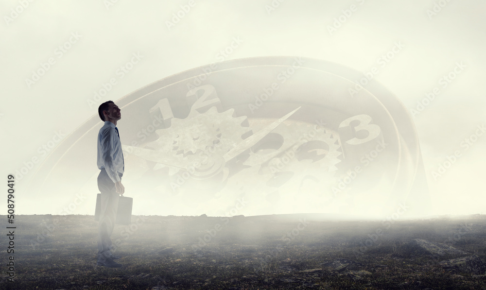 Back view of young businessman while standing with mist background Back view of young businessman while standing with mist background