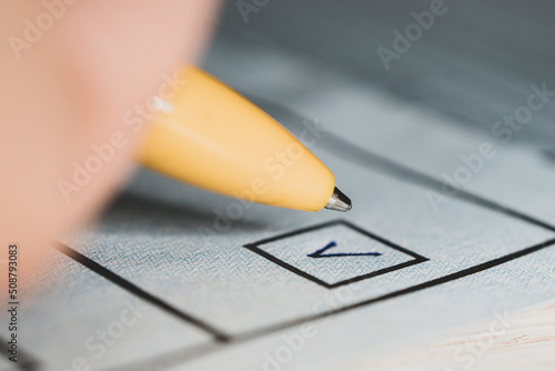 Writing A Check Mark In Checkbox With A Pen On Paper - Every Vote Counts Concept, a mark in the selection and a close-up pen. a checkbox for voting. Presidential or parliamentary elections photo