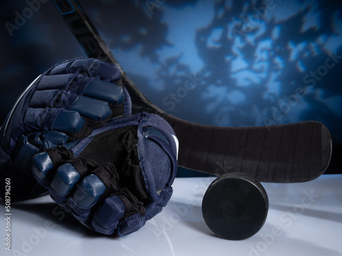 Closeup of ice hockey equipment against a dark background. Ice hockey helmet, stick, puck and gloves photo