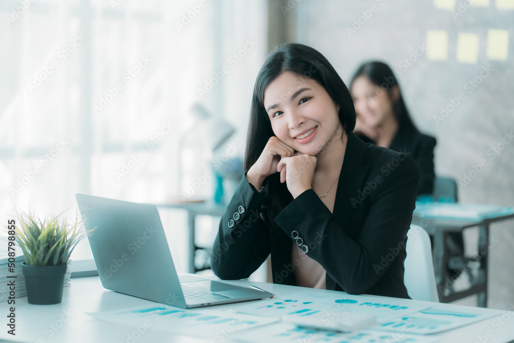 Businesswoman or accountant using the phone to check business information. Accounting Documents and Laptop Computer at Office Business Ideas Businesswoman or accountant using the phone to check business information. Accounting Documents and Laptop Computer at Office Business Ideas