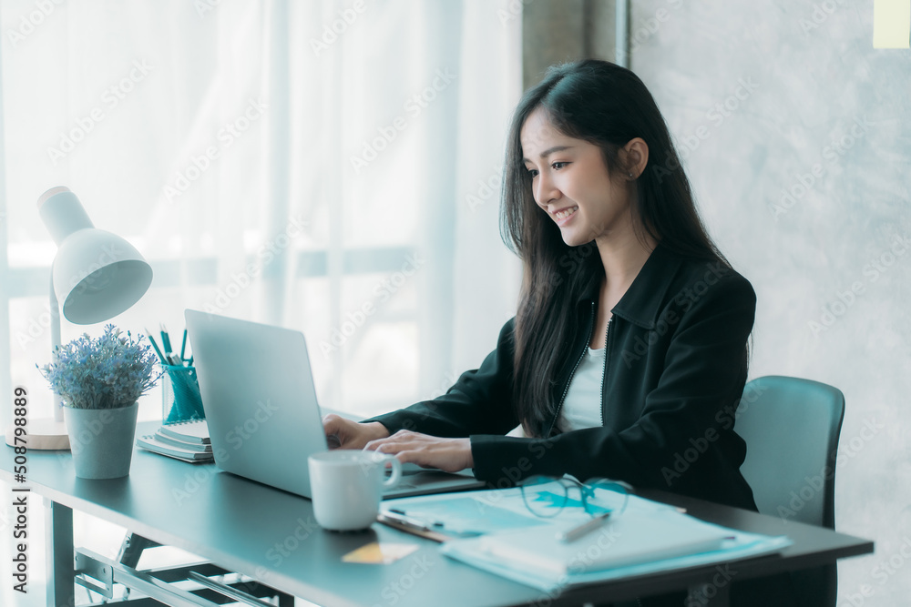 Businesswoman or accountant using the phone to check business information. Accounting Documents and Laptop Computer at Office Business Ideas Businesswoman or accountant using the phone to check business information. Accounting Documents and Laptop Computer at Office Business Ideas