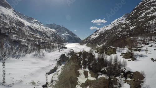 Lake of a frozen dam between snow-capped mountains