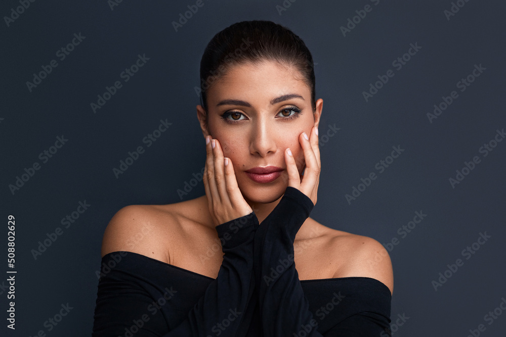 Beauty portrait of hispanic latina woman touching her face.  Young beautiful brunette model against grey background. - obrazy, fototapety, plakaty 