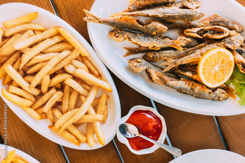 french fries and grilled fishes. fish and chips. Dish with Mullet Fish With orange. Fried fry