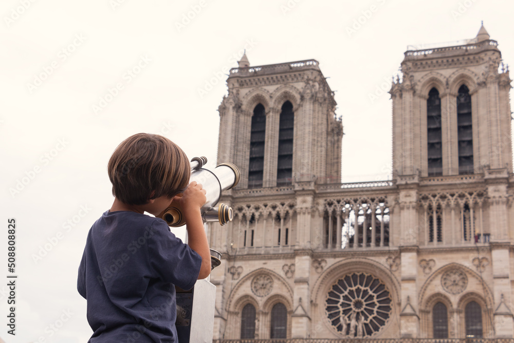 Child looking the Notre Dame Cathedral in the background on vacation