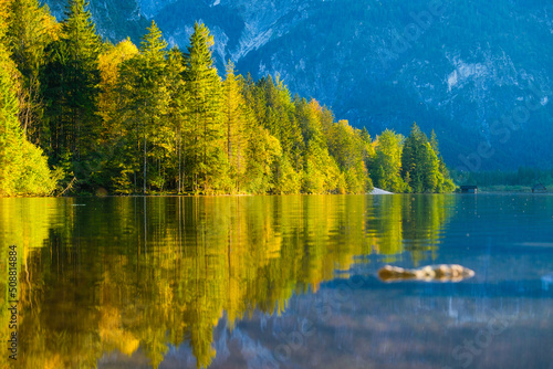 High mountains and reflection on the surface of the lake. The forest near the...