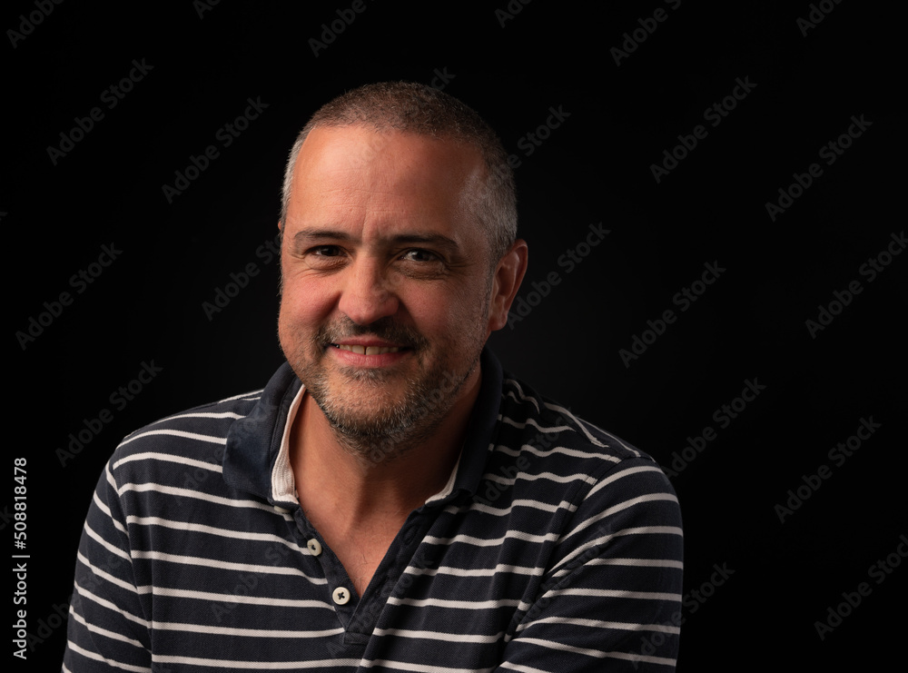 Fototapeta premium Smiling man on black background with copy space