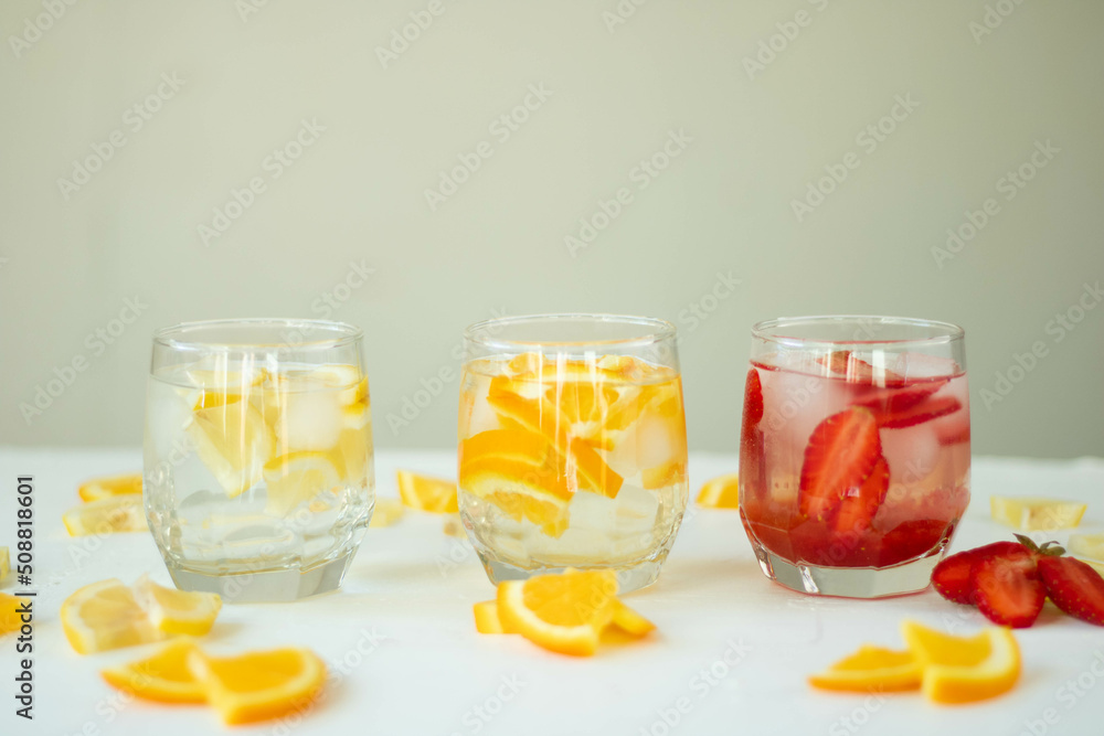 Three refreshing summer drinks with lemon, strawberry and orange Three refreshing summer drinks with lemon, strawberry and orange