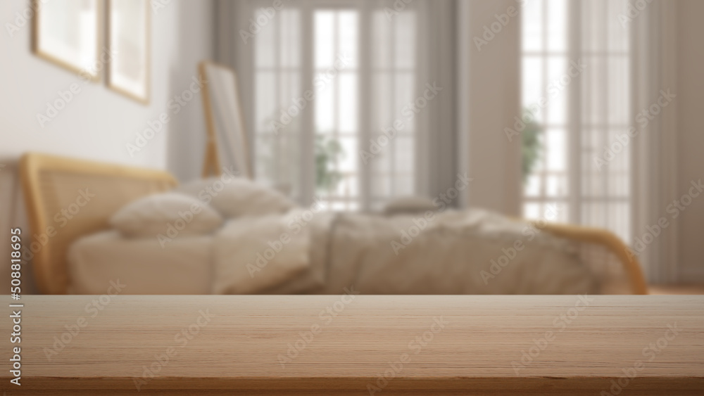 Fototapeta premium Empty wooden table, desk or shelf with blurred view of contemporary white bedroom, rattan bed with duvet, frames and mirror, windows, modern interior design concept