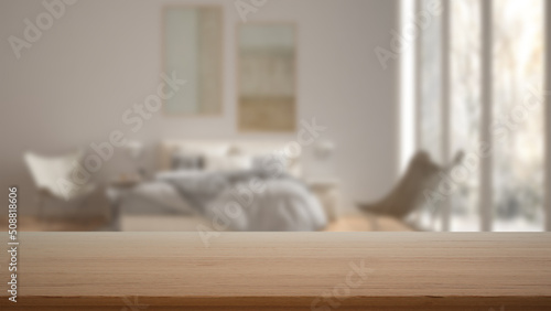 Empty wooden table, desk or shelf with blurred view of scandinavian white bedroom, bed with pillows, armchairs and window, modern interior design concept