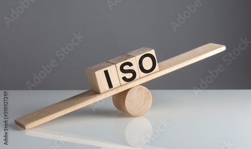 ISO text on wooden cubes on a wooden balance , business concept © Iryna