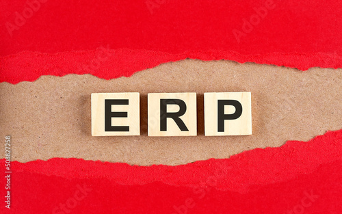 ERP word on wooden cubes on red torn paper , financial concept background