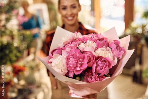 Fotografia Close up of florist holding beautiful floral bouquet at flower shop