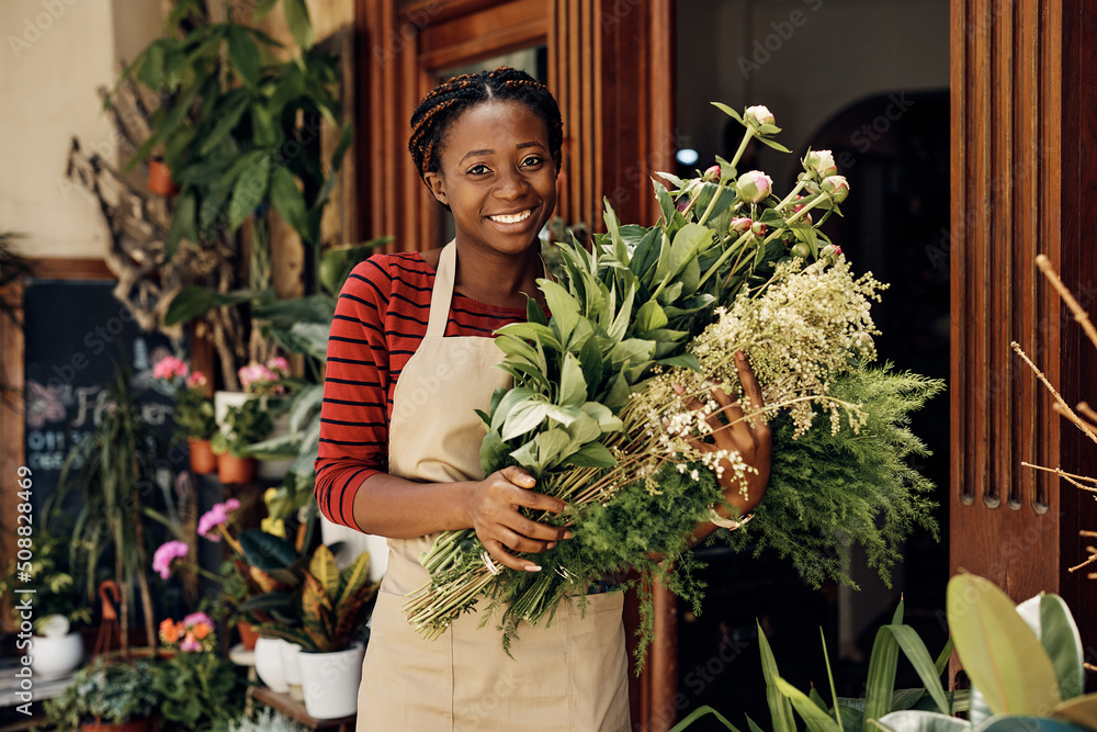 Happy African American woman working as florist and holding bouquets while looking at camera. Happy African American woman working as florist and holding bouquets while looking at camera.