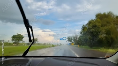 Driving a car on a Brazilian road on a small stretch with rain on a predominantly sunny day.