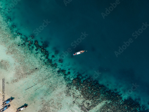 Boats anchored by the reef in turquoise waters of Koh Phi Phi Islands, in Thailand
