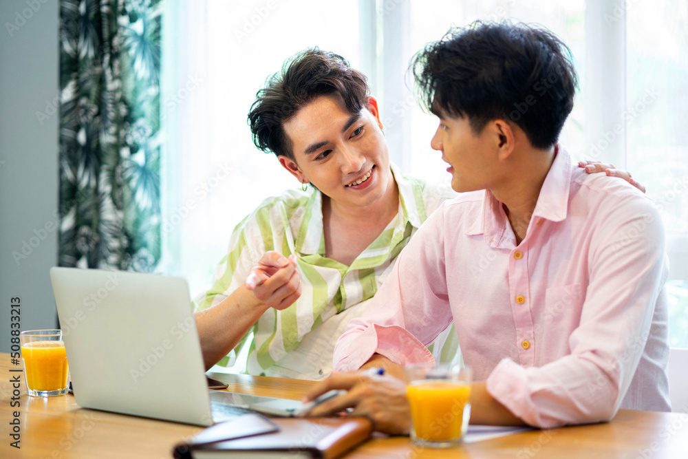 Portrait of carefree gay couple talking throught their home finances Portrait of carefree gay couple talking throught their home finances