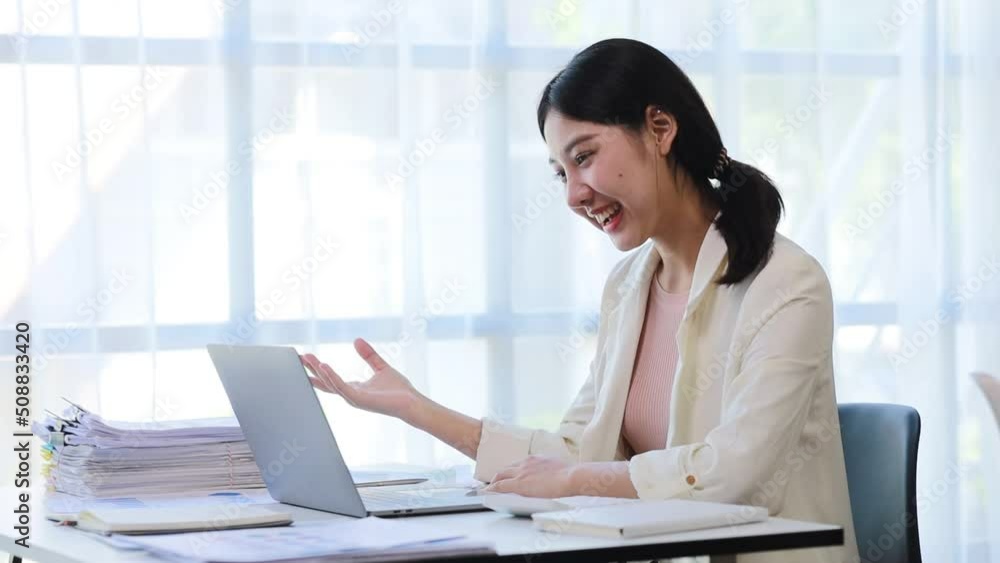 Beautiful Asian businesswoman sitting in her private office, she is talking to her partner via video call on her laptop, she is a female executive of a startup company. Concept of financial management Beautiful Asian businesswoman sitting in her private office, she is talking to her partner via video call on her laptop, she is a female executive of a startup company. Concept of financial management