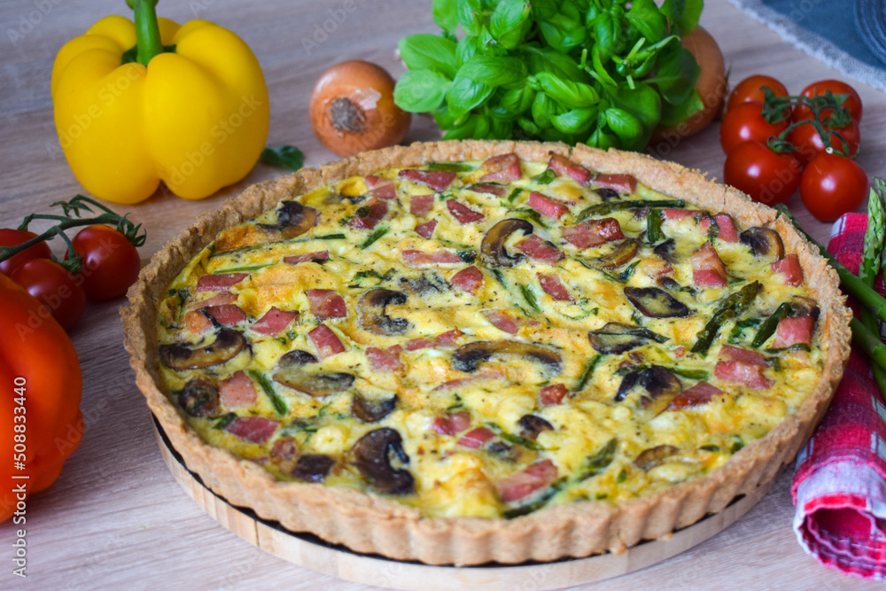 Quiche Lorraine Tart. Quiche is a tart consisting of pastry crust filled with eggs custard and pieces of cheese, bacon, and asparagus.