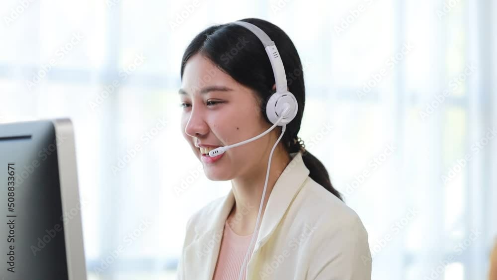 Beautiful Asian woman, she is a call center employee of an Internet and telephone company, she is responsible for providing service and assistance to customers through the phone. Call center concept. Beautiful Asian woman, she is a call center employee of an Internet and telephone company, she is responsible for providing service and assistance to customers through the phone. Call center concept.