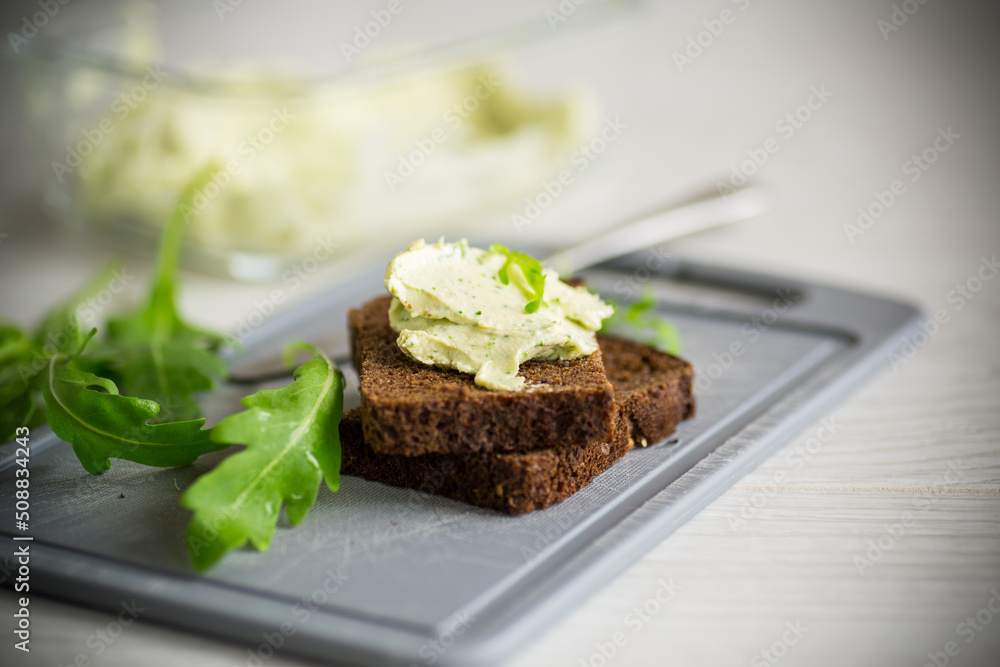 bread cheese spread with garlic and arugula on dark bread bread cheese spread with garlic and arugula on dark bread
