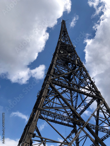 Metal tower on a background of blue sky with white clouds.