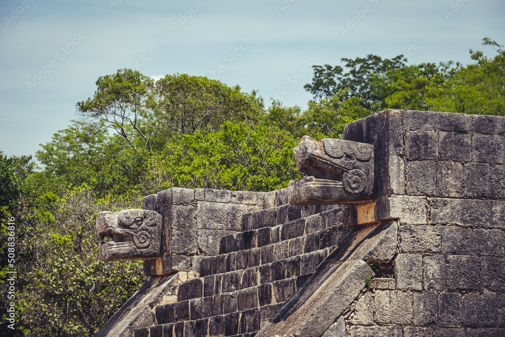 detail of carved stone gods in Chichen Itza mayan ruins stone pyramids in Mexico Yucatan