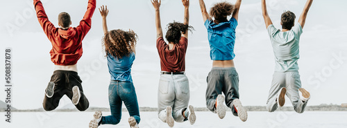 group of cheerful young multiracial friends jump over white background photo